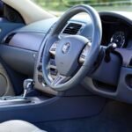 Elegant interior of luxury car featuring steering wheel and dashboard.